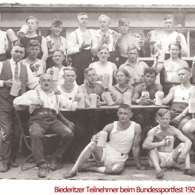 Gruppe von Männern beim Bundessportfest 1927 in Nürnberg, die Bierkrüge halten und auf einer Terrasse posieren.