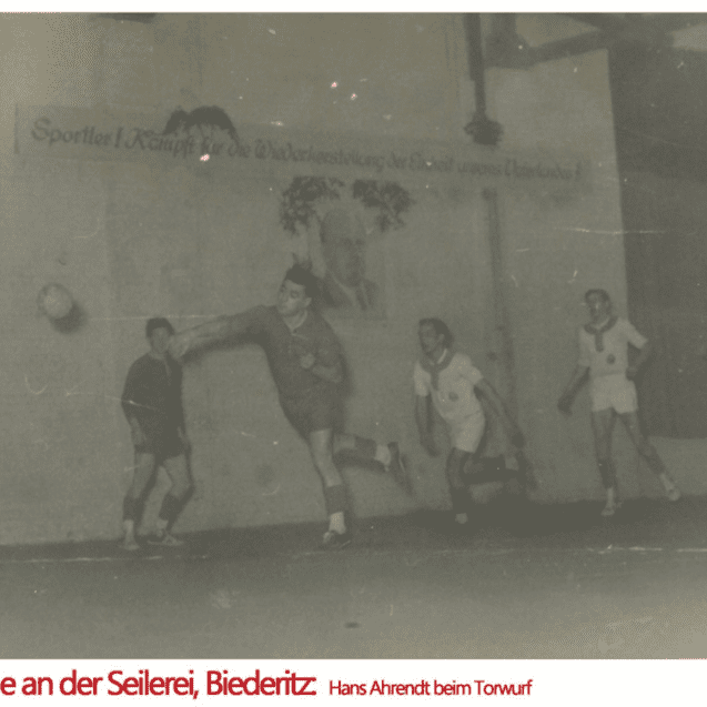 Spielszene von 1953 in einer Halle in Biederitz, ein Spieler wirft den Ball in Richtung Mitspieler.