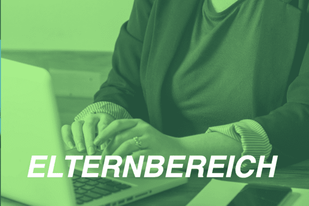 Frau mit Blazer sitzt an einem Tisch und tippt auf einem Laptop, ein Notizbuch und ein Handy liegen daneben.