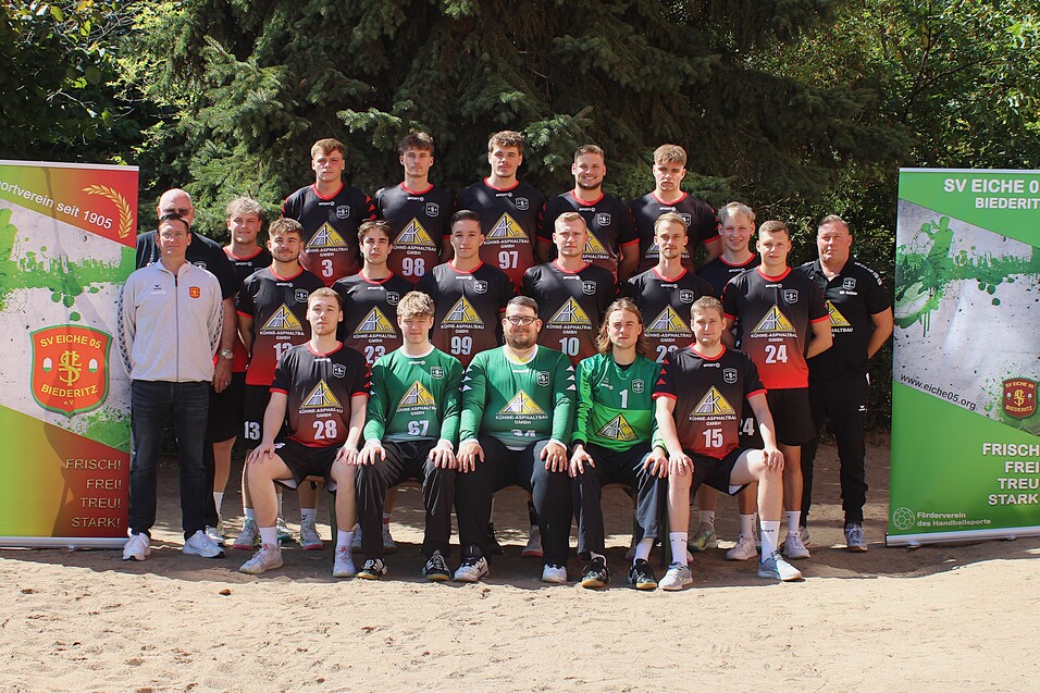 Mannschaftsfoto der Jugendmannschaft des SV Eiche 05 Biederitz mit Trainern und Spielern in einheitlichen Trikots auf Sandplatz.
