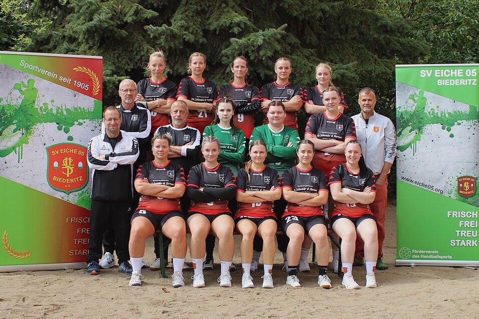 Mannschaftsfoto der Damenmannschaft von SV Eiche 05 Biederitz, umgeben von Vereinsbanner im Freien.